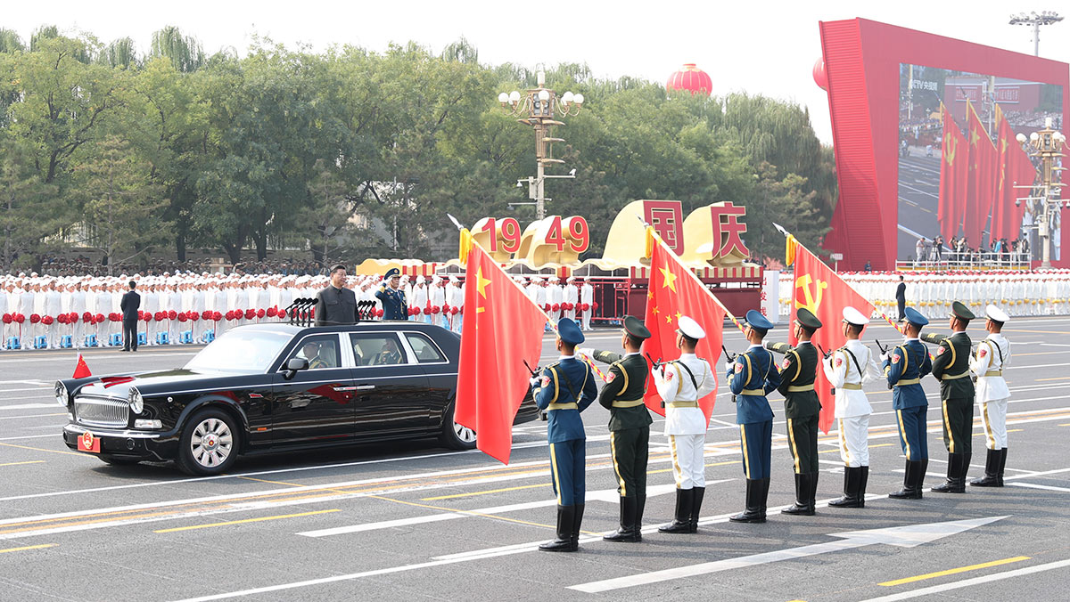 習(xí)近平驅(qū)車行進(jìn)至黨旗、國旗、軍旗前，向旗幟行注目禮